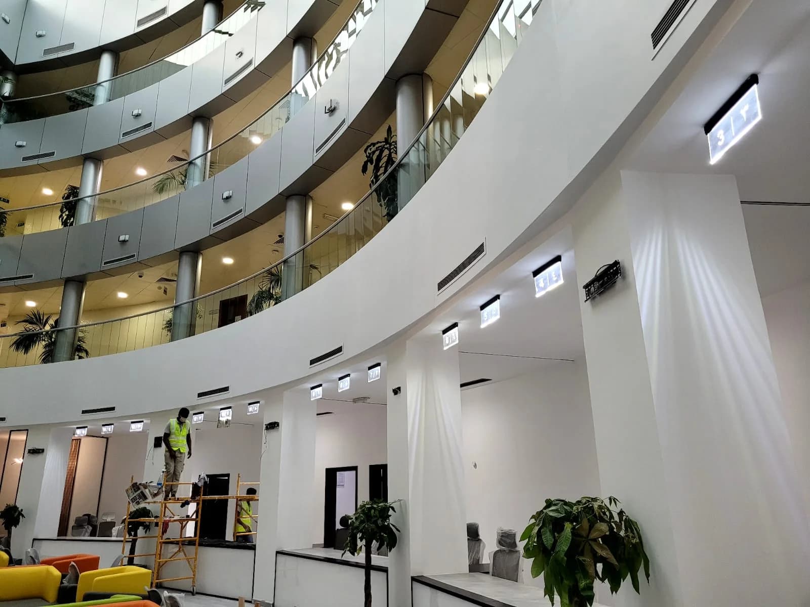 Fit-out works in a multi-storey commercial atrium, with a team installing counter-area finishes