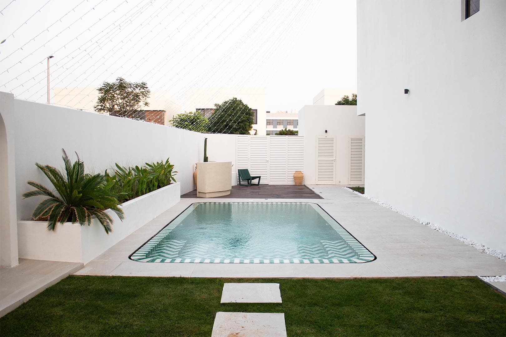 Chevron-tiled swimming pool in a white-walled villa courtyard, Abu Dhabi