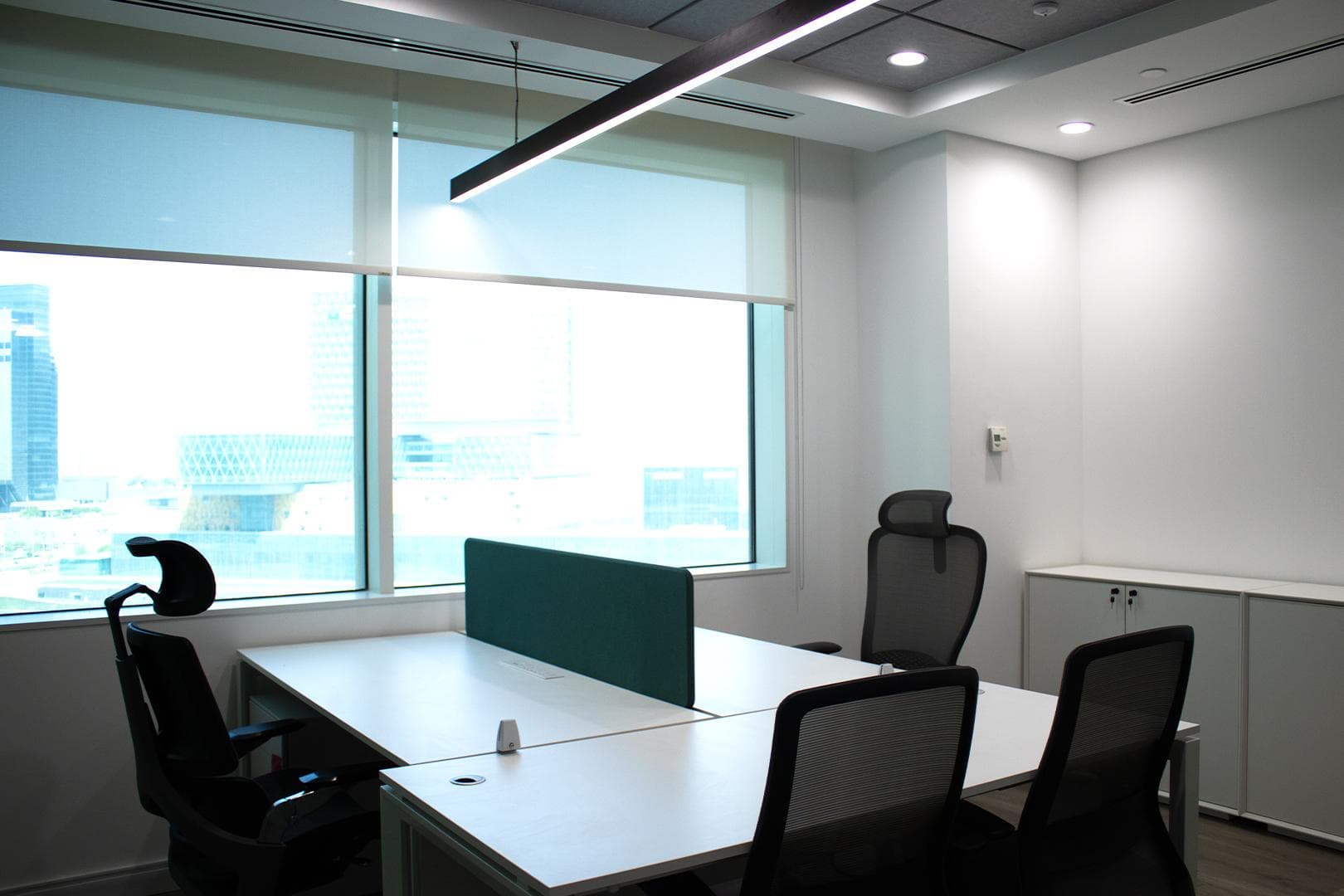 Private office with linear pendant lighting, HVAC and roller-blind glazing