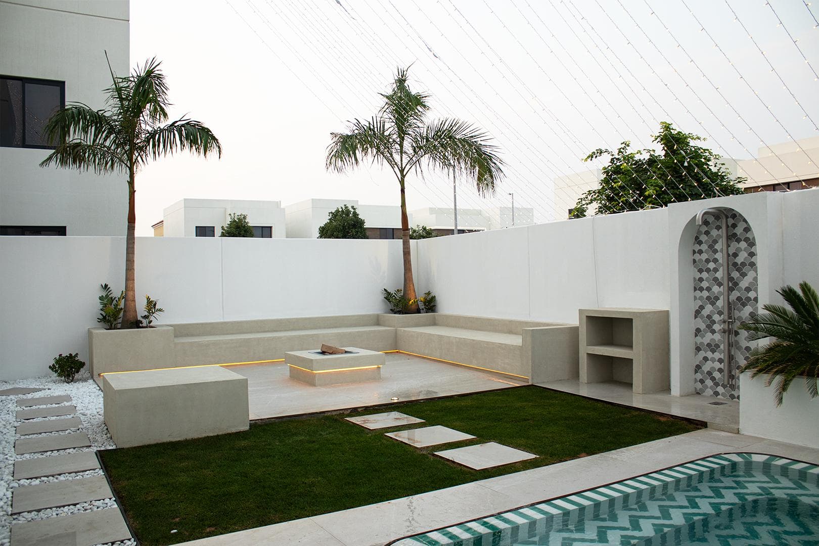 Courtyard terrace with built-in benches, planted beds and decorative screen niches, completed by Eagle