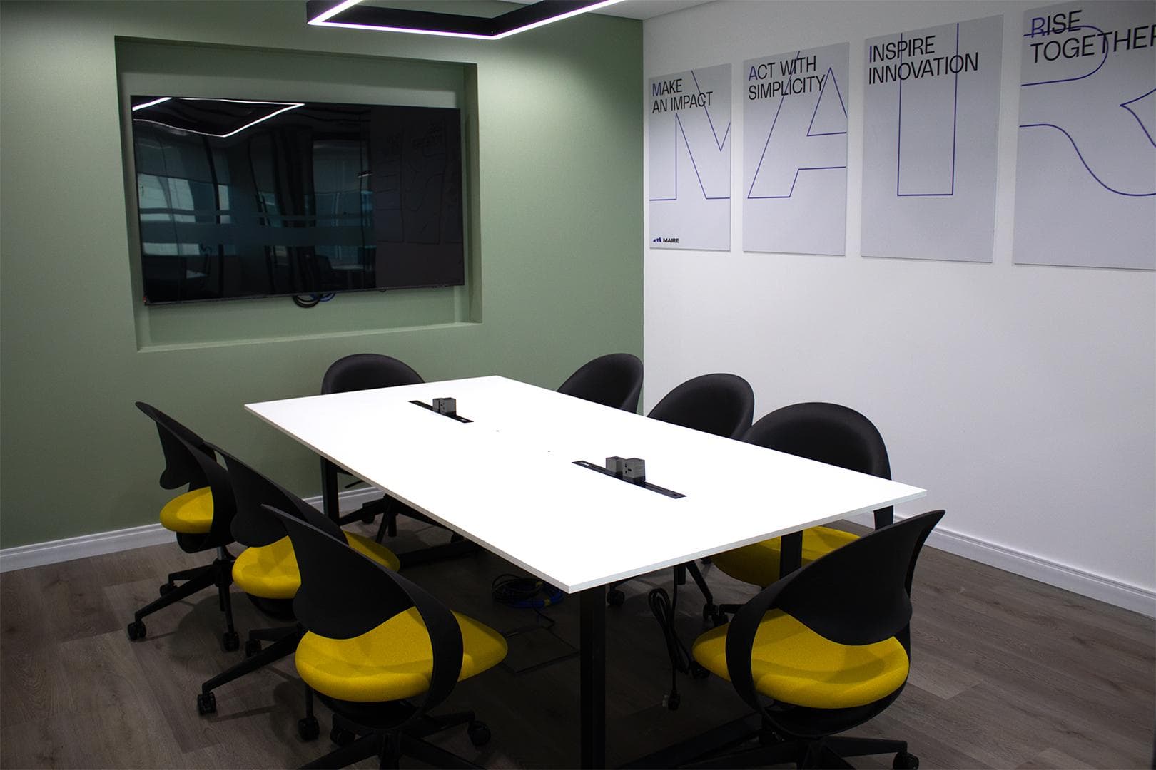 Meeting room with sage feature wall, recessed display and brand posters
