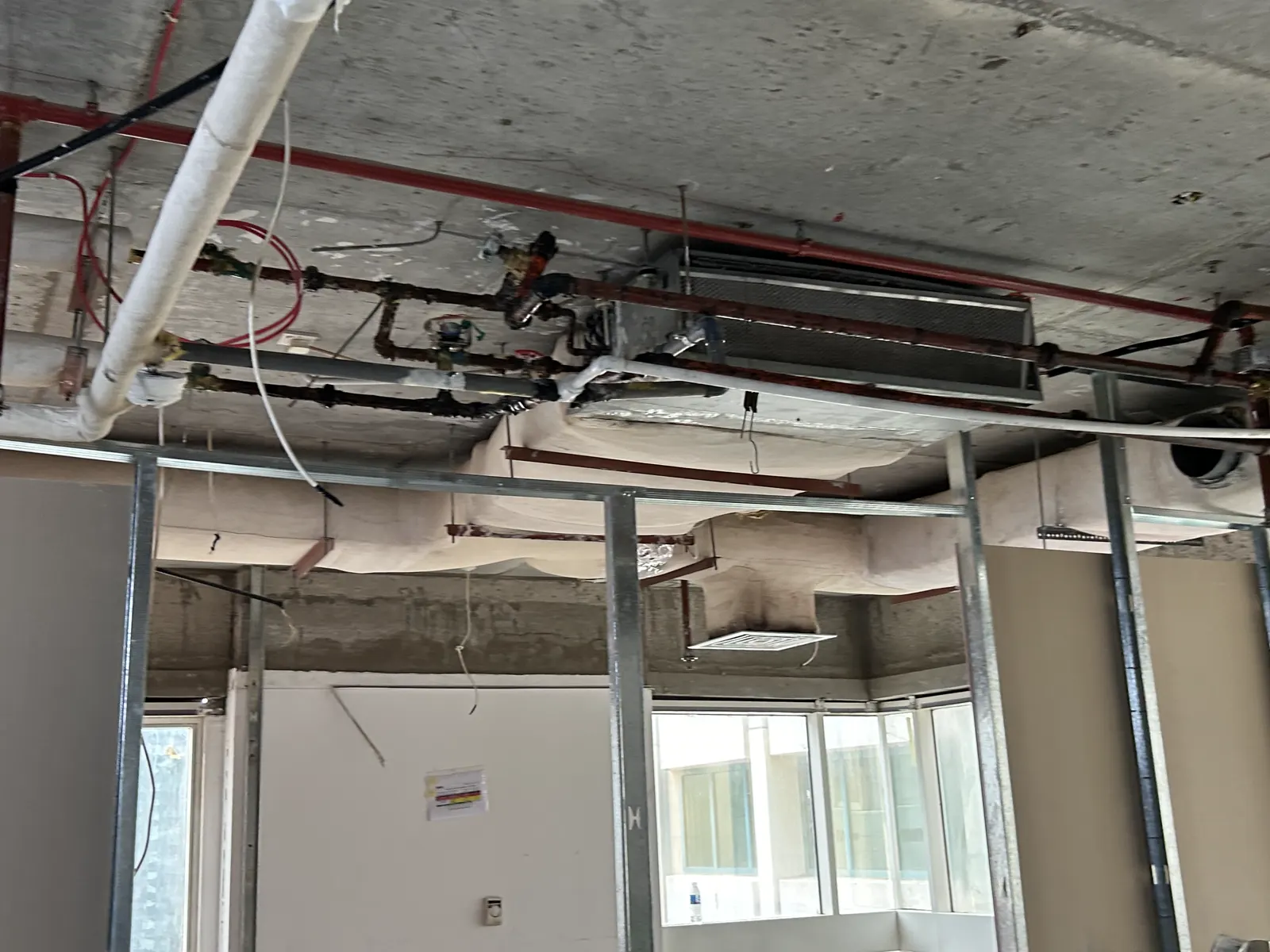 Exposed ceiling void with ductwork, sprinkler pipework and containment coordinated together
